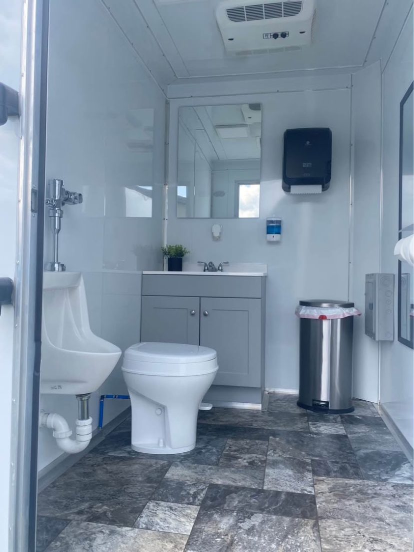 2-stall trailer interior with urinal, toilet, and vanity